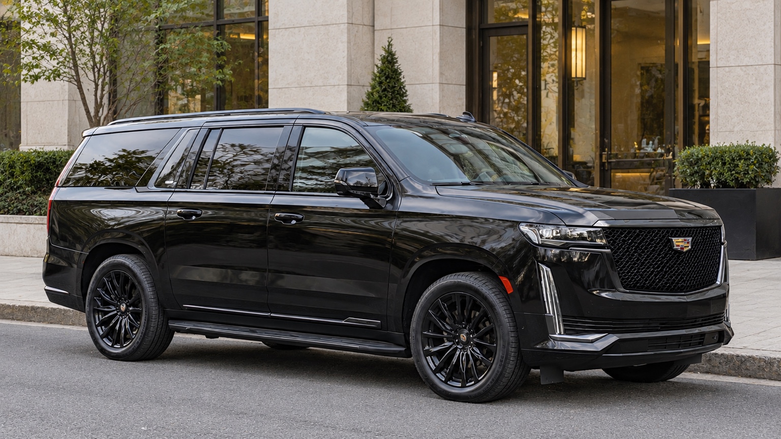 Glossy black Cadillac Escalade ESV parked at a hotel curb